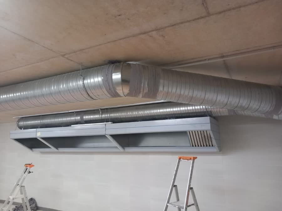 Hotte murale et gaines posées dans un local en travaux