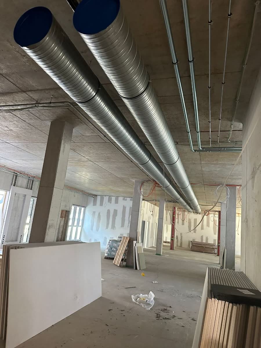 Gaines de ventilation posées dans un plateau de bureaux en chantier