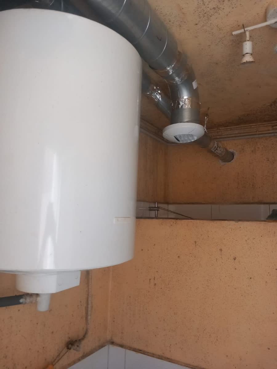 Bouche d'extraction et gaine posées dans un logement